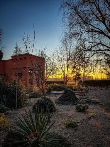 a building with a sunset in the background at Finca La Saucina Casa de Campo in Tunuyán