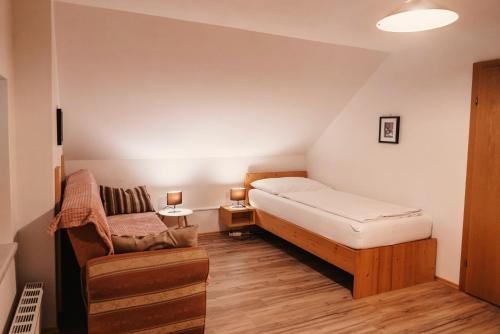 a small bedroom with a bed and a chair at Ferienwohnungen Karin am Seggauberg in Leibnitz