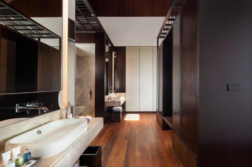 a large bathroom with a tub and a sink at Radisson Blu Bali Uluwatu in Uluwatu