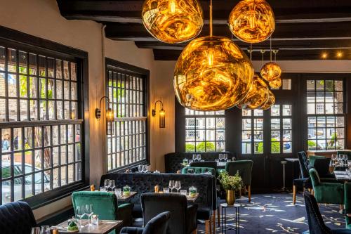 a restaurant with tables and chairs and large windows at Les Maisons de Lea, a member of Radisson Individuals in Honfleur