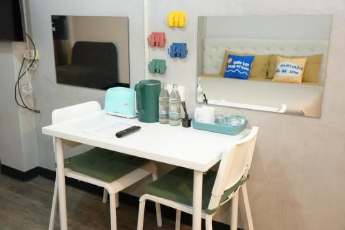 a white table with two chairs and a mirror at Bkk39 Airport hotel in Ban Khlong Prawet