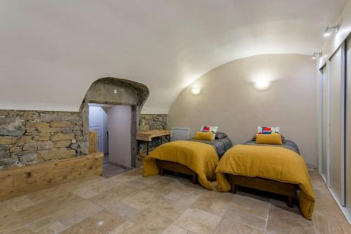 two beds in a room with a stone wall at le loft du vieux lyon in Lyon