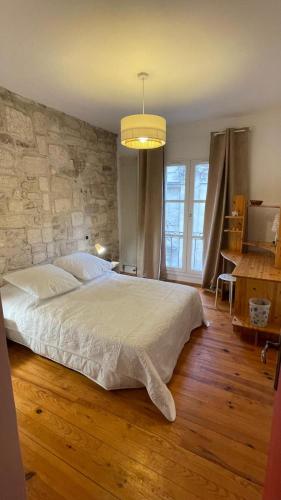 une chambre avec un grand lit et un mur en pierre dans l'établissement Chaleureux Vernet - Terrasse - Clim - Hypercentre, à Avignon