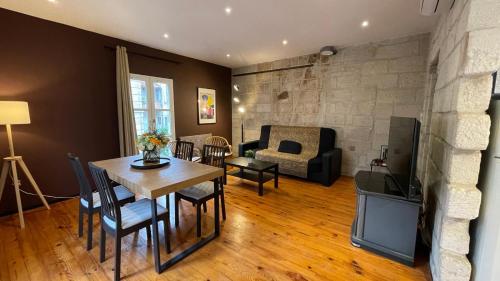 un salon avec une table et un salon avec une cheminée dans l'établissement Chaleureux Vernet - Terrasse - Clim - Hypercentre, à Avignon