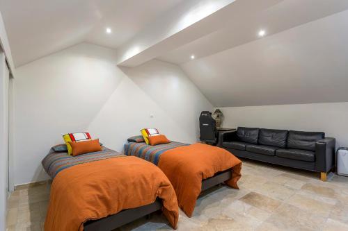 two beds in a room with a couch at le loft du vieux lyon in Lyon