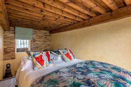 a bed in a room with a wooden ceiling at le loft du vieux lyon in Lyon