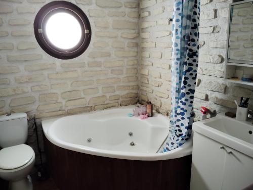 Un baño con bañera, inodoro y lavabo. en L'échappée belle 95, en Goussainville