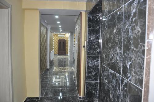 um corredor de um hotel com azulejos de mármore preto em Mevlana Palace em Konya