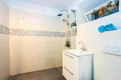 une salle de bain blanche avec lavabo et douche dans l'établissement Secluded fisherman's cottage Ston - Supavao, Peljesac - 9485, à Ston