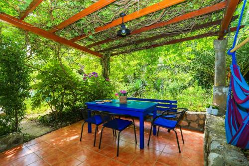 une table bleue et des chaises assises sous une pergola dans l'établissement Secluded fisherman's cottage Ston - Supavao, Peljesac - 9485, à Ston