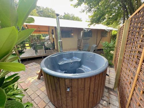 un jacuzzi en el patio trasero de una casa en Libelle, en Hulshorst