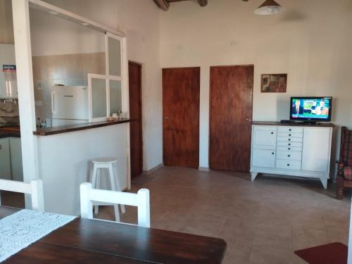 a living room with a dining table and a television at Casas HG-Acepta mascotas-Desayuno sencillo-Pileta climatizada en predio a 2 kilómetros in Huerta Grande