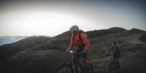 two people riding bikes on a hill at Hotel Alpenblick in Sesto