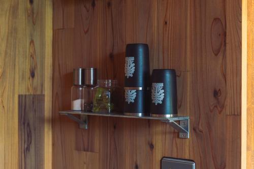 a shelf on a wooden wall with bottles on it at Earthboat Togakushi in Nagano