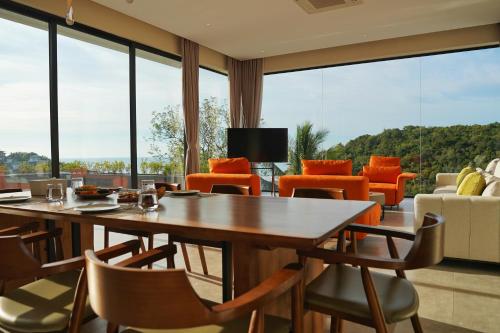 a dining room with tables and chairs and large windows at Green Lotus Samui in Ban Bang Po