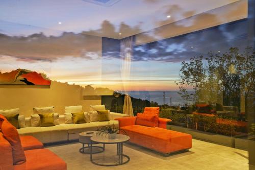 a living room with orange furniture and a large window at Green Lotus Samui in Ban Bang Po