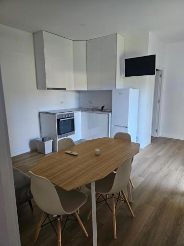 eine Küche mit einem Holztisch und Stühlen in einem Zimmer in der Unterkunft Casa da leira in Madalena