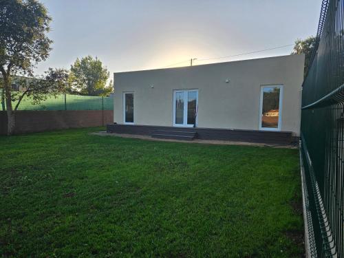 a white house with a fence in a yard at Casa da leira in Madalena