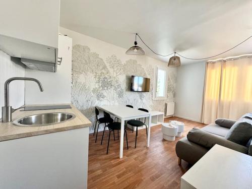 une cuisine et un salon avec une table et un canapé dans l'établissement Appartement deux pièces, Évry-Courcouronnes