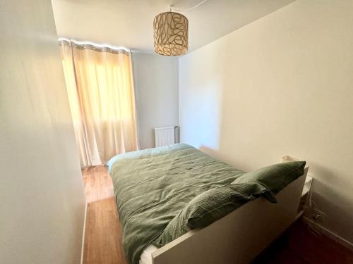 une chambre avec un lit dans une pièce avec une fenêtre dans l'établissement Appartement deux pièces, Évry-Courcouronnes