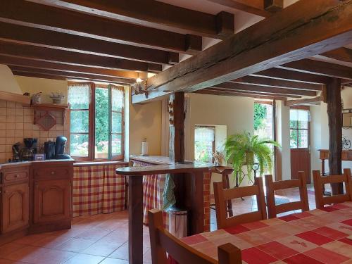 Il comprend une cuisine dotée de poutres apparentes, d'une table et de chaises. dans l'établissement Escapade en longère avec jardin au bord de l'Ozanne, Dangeau, 6 pers. - FR-1-581-25, à Dangeau