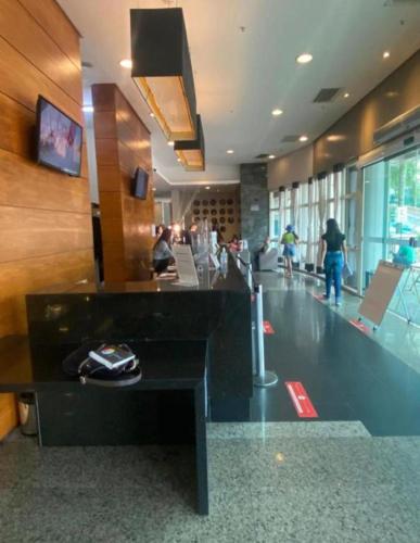 a lobby with people walking in a building at Barra da Tijuca - 508 - De Frente para Maravilhosa Piscina - Estacionamento Gratuito - Academia Comphania Atletica - Balsa para Praia Grátis - Microondas - Geladeira Grande - Recepção 24horas - Wi-Fi - Com Pia in Barra da Tijuca