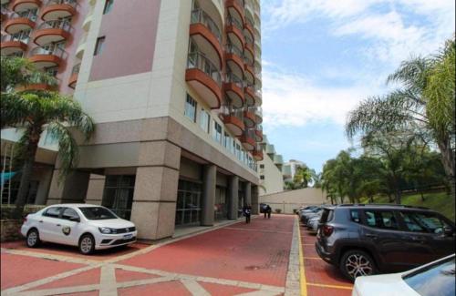 two cars parked in front of a building at Barra da Tijuca - 508 - De Frente para Maravilhosa Piscina - Estacionamento Gratuito - Academia Comphania Atletica - Balsa para Praia Grátis - Microondas - Geladeira Grande - Recepção 24horas - Wi-Fi - Com Pia in Barra da Tijuca
