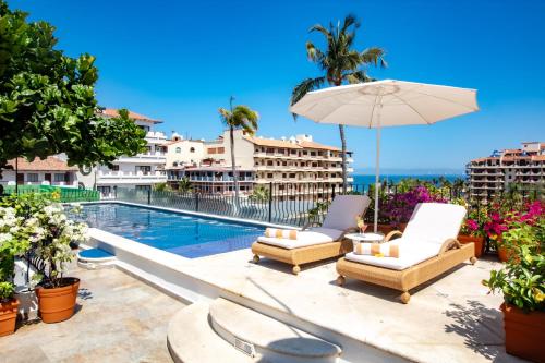 a patio with chairs and an umbrella and a swimming pool at Casa Doña Susana in Puerto Vallarta