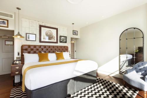 a bedroom with a large bed and a chair at Hotel Indigo - Edinburgh - Princes Street by IHG in Edinburgh