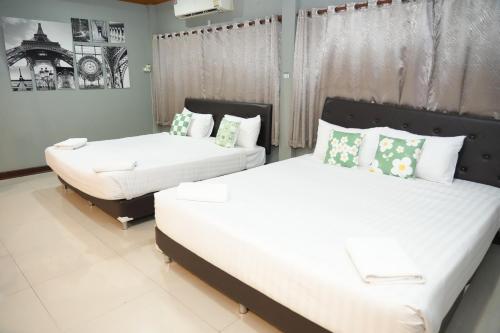 a bedroom with two beds and a window at Bkk39 Airport hotel in Ban Khlong Prawet