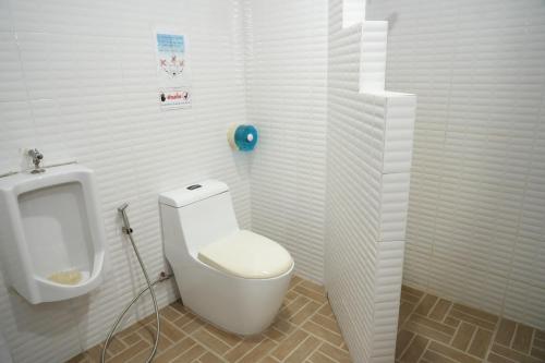 a bathroom with a white toilet and a urinal at Bkk39 Airport hotel in Ban Khlong Prawet