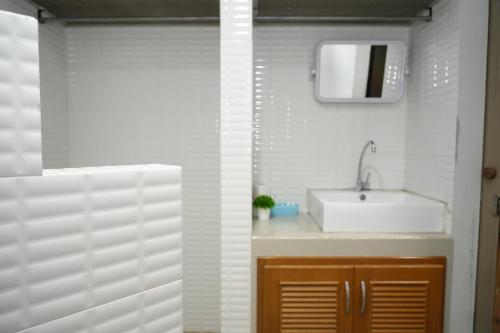 a bathroom with a sink and a mirror at Bkk39 Airport hotel in Ban Khlong Prawet