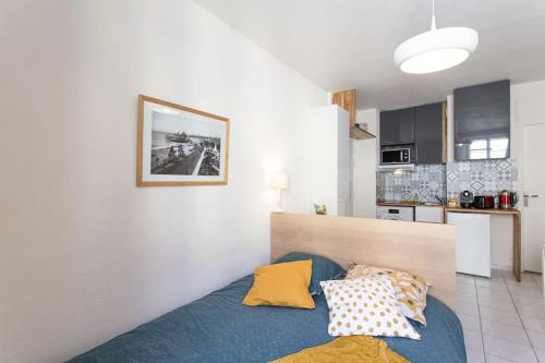 une chambre avec un lit bleu et une cuisine dans l'établissement Studio Maréchal Jean Medecin Hyper centre, à Nice