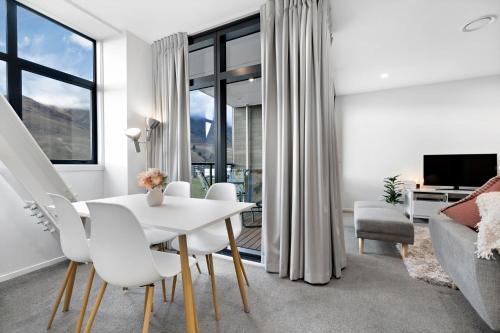 a living room with a white table and chairs at Haeata View in Queenstown