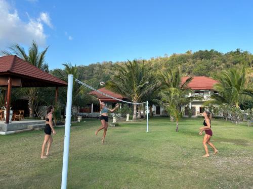 a group of women playing a game of volleyball at Mama Nings Beach Hotel in Sekongkang
