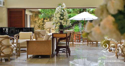 a restaurant with a table and chairs and flowers at The Naha Terrace in Naha