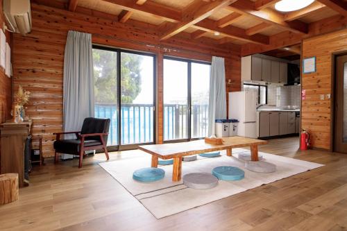 a living room with a table and a kitchen at ocean resort mint オーシャンビューを満喫!かわいい三角屋根の三階建て貸切別荘 南房総白浜 in Shioura