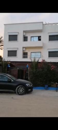Un coche negro aparcado delante de un edificio en Maison omar, en Agadir