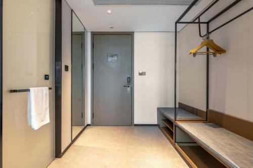 a walk in shower in a room with a mirror at Atour Hotel Changshu Yunshang Town Mocheng Avenue in Changshu