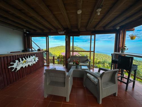 a living room with chairs and a table on a balcony at Loma Nevada Minca Hotel in Minca