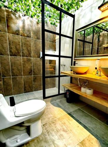 a bathroom with a white toilet and a sink at Espectacular casa Campestre con Jacuzzi in Salento