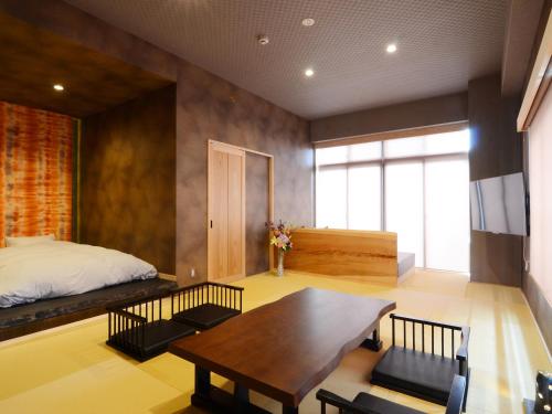 a bedroom with a bed and a wooden table at 日本旅館 器 別府鉄輪 nihonryokan utsuwa beppukannnawa in Beppu