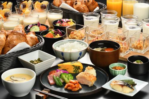 a table topped with plates of food and bowls of food at Towada Prince Hotel in Kosaka