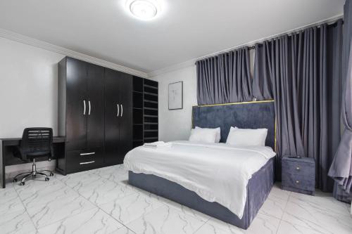 a bedroom with a bed and a desk and a chair at Spacious 3 bed - Fast Internet - Free Parking - Swimming Pool in Lagos