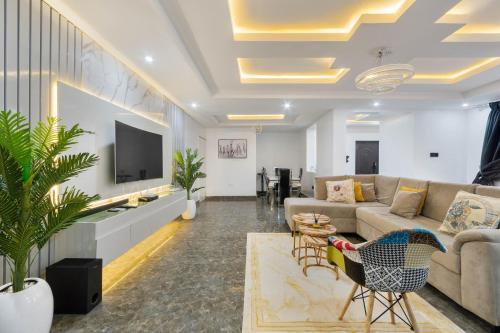 a living room with a couch and a tv at Spacious 3 bed - Fast Internet - Free Parking - Swimming Pool in Lagos