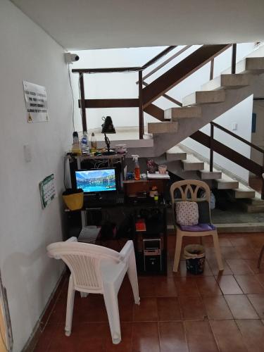 a living room with a staircase and a table and chairs at Linda casa vacacional Andy-Santiago de Cali in Cali
