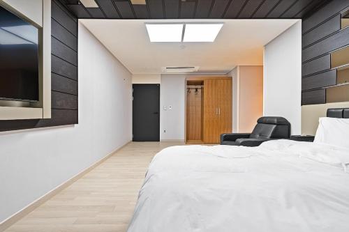 a bedroom with a bed and two chairs at Pohang A1Hotel Haedo in Pohang