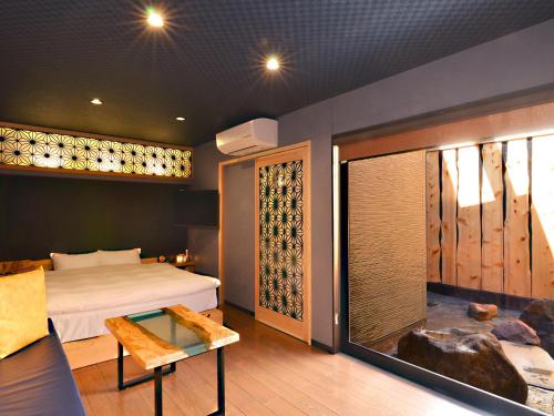 a bedroom with a bed and a room with a window at 日本旅館 器 別府鉄輪 nihonryokan utsuwa beppukannnawa in Beppu
