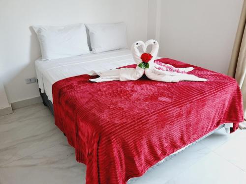 a bedroom with a bed with a red blanket at Ap no Coração de Porto de Galinhas Paulo Brito 101 - By Anfitrião Legal in Porto De Galinhas