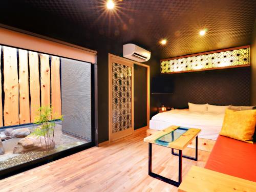 a bedroom with a bed and a window and a table at 日本旅館 器 別府鉄輪 nihonryokan utsuwa beppukannnawa in Beppu